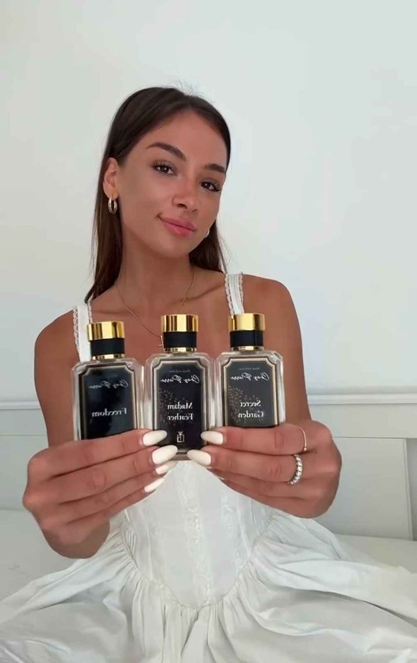 A woman holding an elegant Chez Pierre perfume bottle while enjoying her day in Dubai